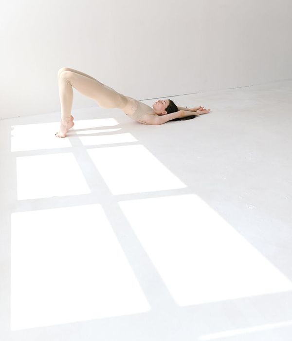Woman in a peaceful yoga pose in a bright studio environment.